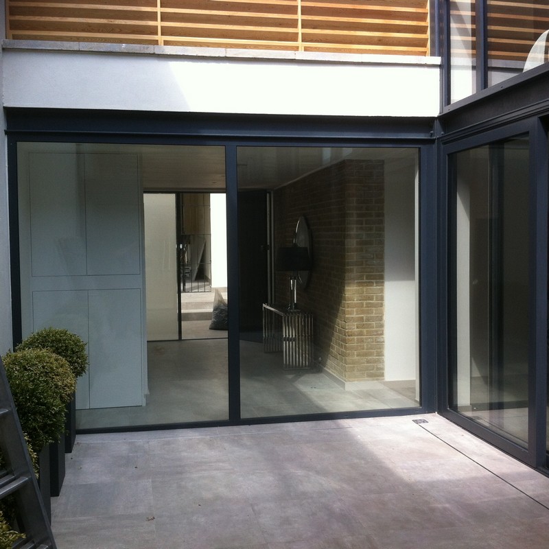 Floor-to-ceiling sliding doors opening to courtyard in Mill Hill